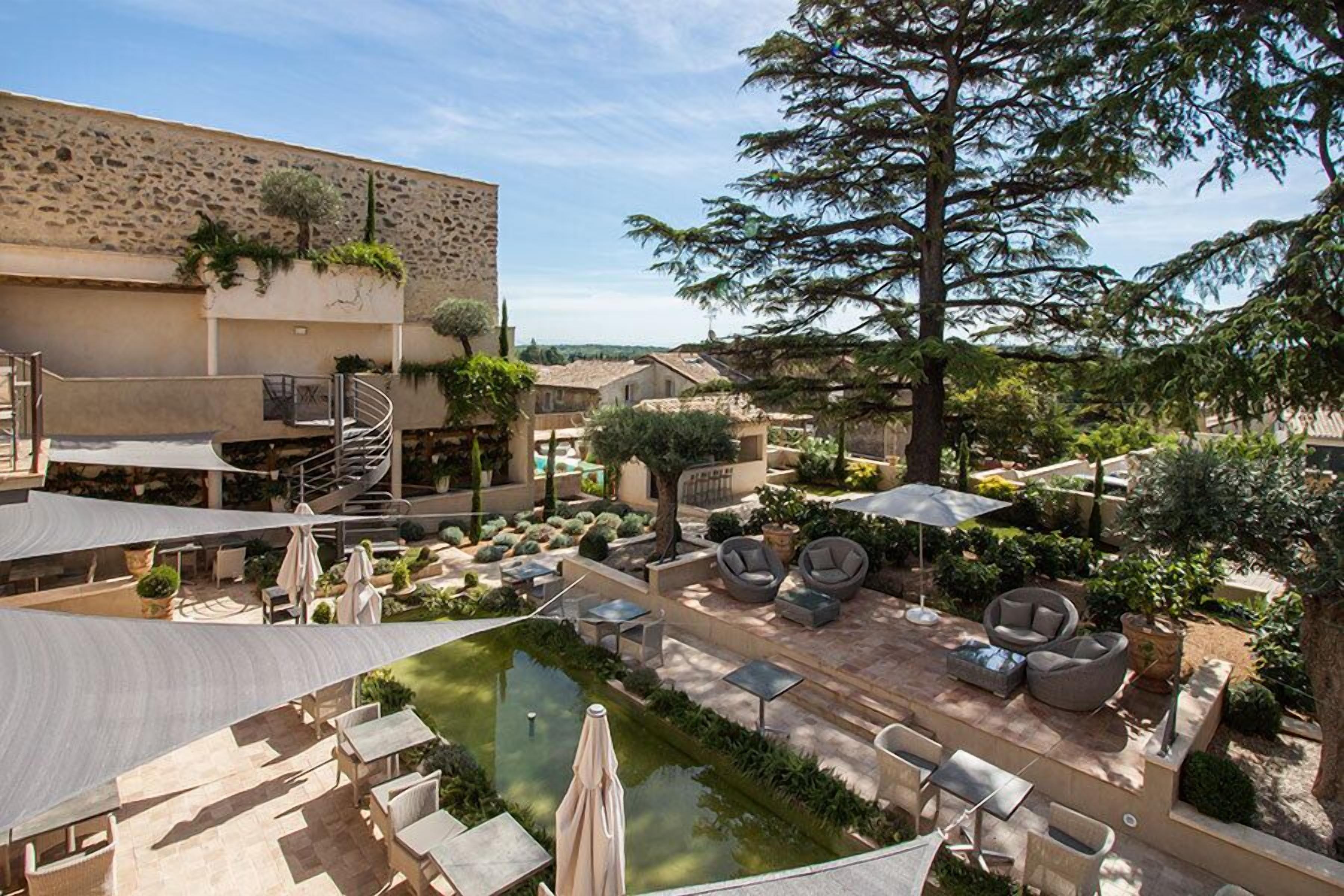 A courtyard with outdoor seating, a pool, and a staircase leading to an upper level.