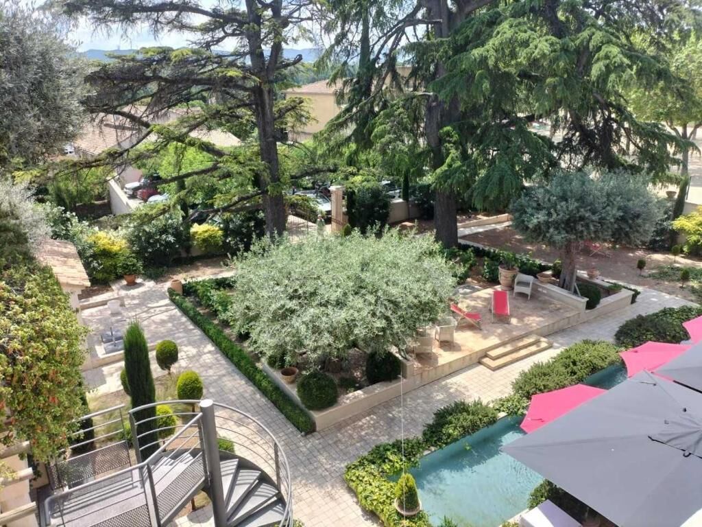 Un jardin sur le toit avec une piscine, des espaces de détente en plein air et un escalier.