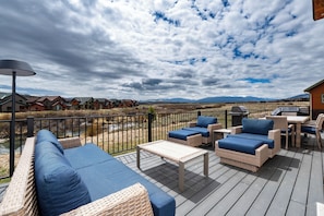 A deck with wicker furniture, a table, and a view of mountains. - Magnificent mt home, private HT, mt views, game room and more! (Tabernash)