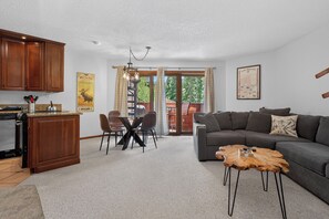 Un salon comprenant un canapé, une table basse et un coin repas avec des chaises et une table.