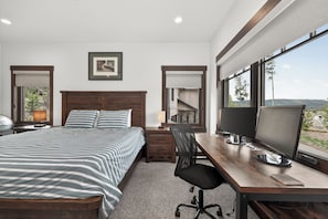 A hotel room with a bed, desk, computer, and large windows. - 4 bedroom home, private HT, 2 living spaces and close to trails (Fraser)