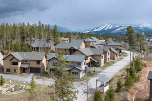 A residential area with houses, a road, and a mountain range in the background. - 4 bedroom home, private HT, 2 living spaces and close to trails (Fraser)
