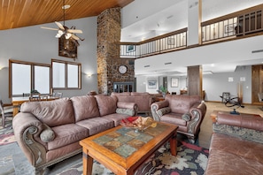 A spacious living room with leather sofas, a wooden coffee table, and a stone fireplace. - Iron Horse Building D Unit 3074 High end studio, ski-in/ski-out, forest views (Winter Park)