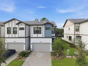 A modern residential building with a garage, a driveway, and a well-maintained lawn. - Luxury 5BR Villa w/ 4 Private Suites | Heart of Orlando (Orlando)
