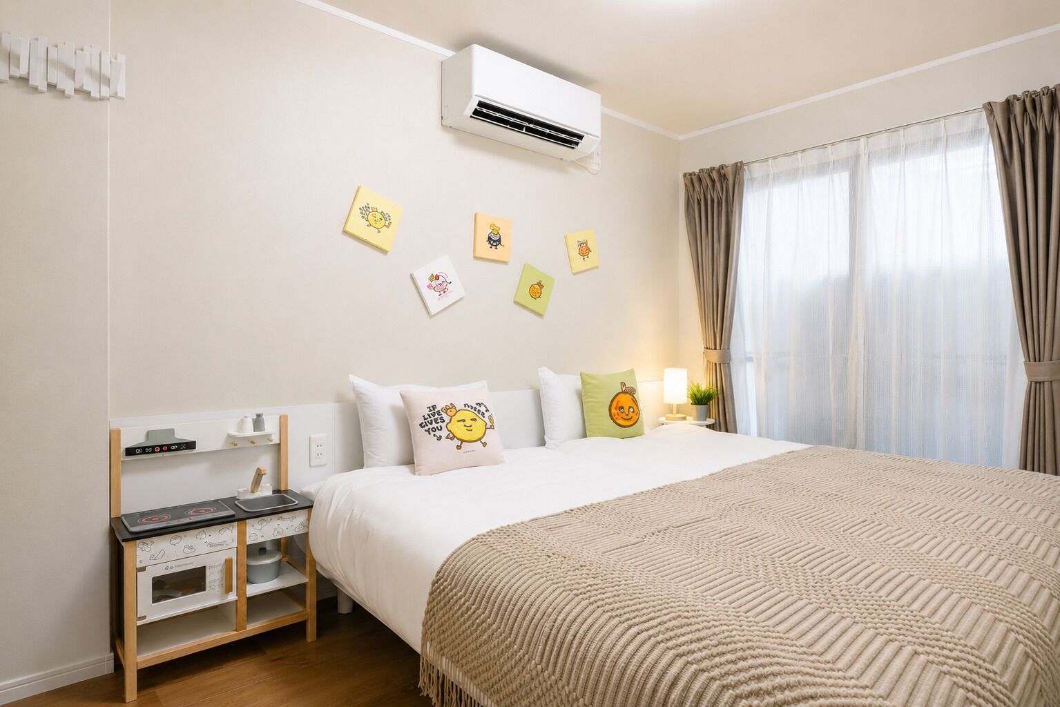 A hotel room with a bed, bedside table, air conditioning unit, and a window with curtains.