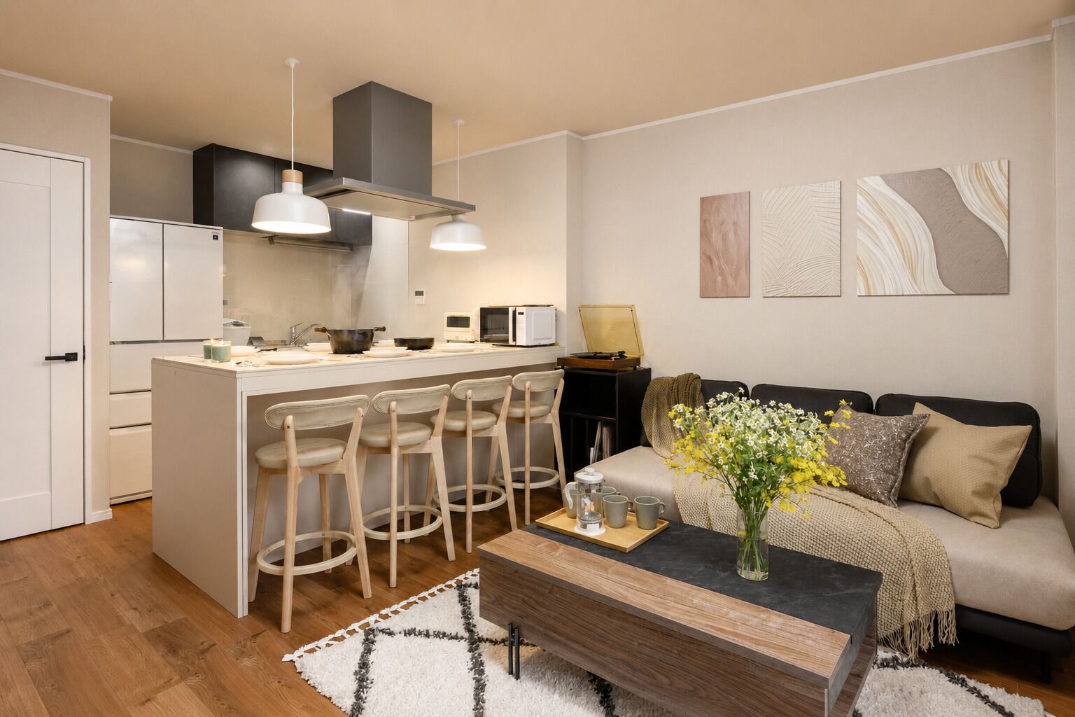 A modern kitchen with a central island, bar stools, a sofa, and a coffee table.