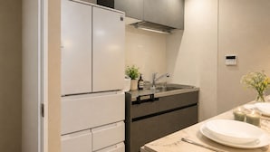 Una cuina moderna amb nevera integrada, un vàter d'acer inoxidable i un taulell de marbre.