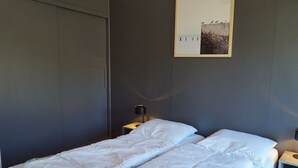 A hotel room with a bed, a nightstand, a lamp, and a framed picture on the wall. - Holiday Home in Arnhem With Terrace (Arnhem)