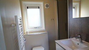 A bathroom with a toilet, a window, a radiator, a sink, and a mirror. - Holiday Home in Arnhem With Terrace (Arnhem)