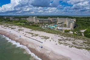 Ein Resort mit mehreren Gebäuden, einem Strand und einem Schwimmbad.
