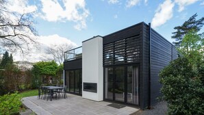 A modern house with a patio, a dining area, and a fireplace. - Holiday Home in Otterlo With Terrace (Otterlo)
