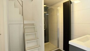 A modern bathroom with a shower, a bathtub, and a staircase leading to another room. - Holiday Home in Otterlo With Terrace (Otterlo)