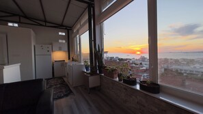 Una cocina moderna con vista a la puesta de sol sobre el mar.