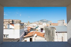 Paesaggio urbano con edifici, una montagna e cielo sereno.