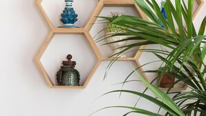 A wall with hexagonal wooden shelves holding various decorative items. - Charming Cassaro apartment with private terrace (PALERMO)