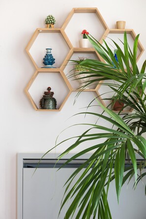 A wall with hexagonal wooden shelves holding various decorative items. - Charming Cassaro apartment with private terrace (PALERMO)