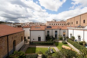 Un patio con edificios, césped y una estatua.