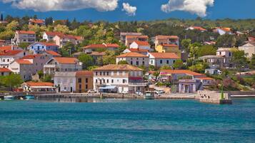 A coastal town with buildings along the waterfront, a clear sky, and calm sea.