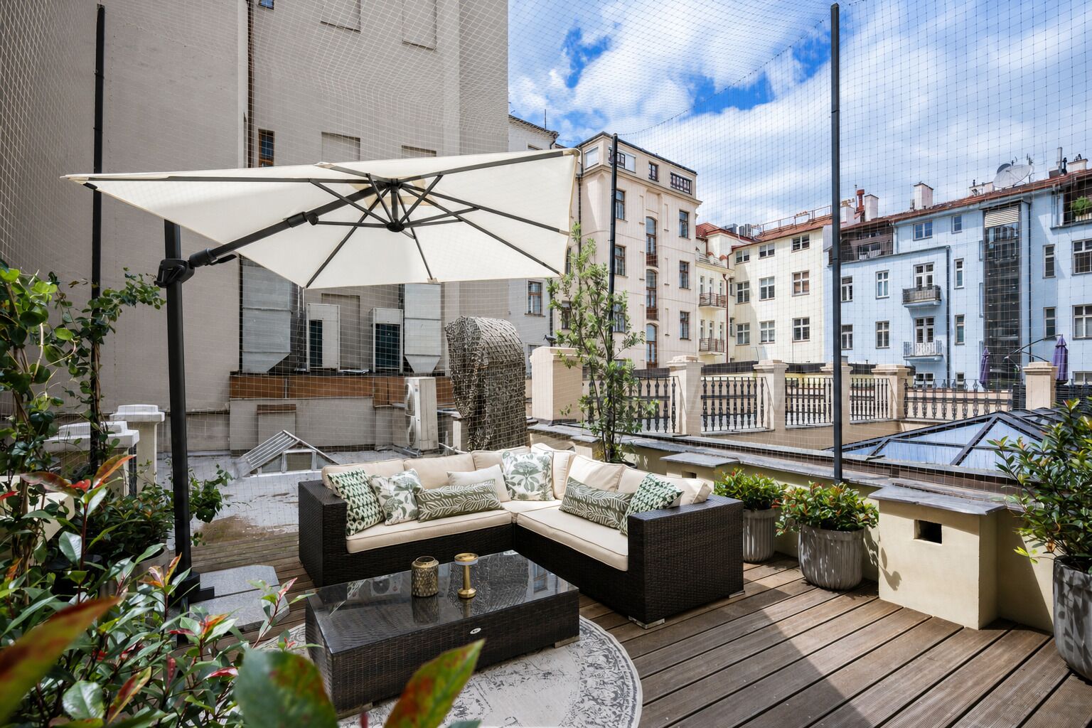 Eine Dachterrasse mit einer Couch, einem Tisch und einem Sonnenschirm.