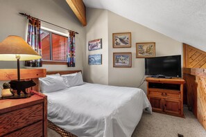 A bedroom with a bed, a lamp, a TV, and wall art. - Close to Skiing & Town, Spacious 2BR + Loft (Breckenridge)