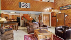 A spacious living area with a fireplace, leather furniture, and a wooden ceiling. - Ski-In Mountain Condo | Perfect for Families & Groups (Breckenridge)