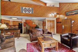 A spacious living area with a fireplace, leather furniture, and a wooden ceiling. - Ski-In Mountain Condo | Perfect for Families & Groups (Breckenridge)