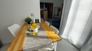 Ein Esstisch mit Flasche und Gläsern, einer kleinen Pflanze und einem Schild an der Wand.