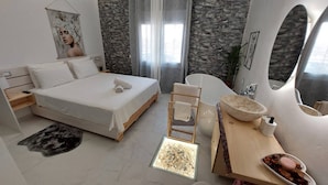 Quarto moderno com cama, banheira, toucador e uma pequena janela.