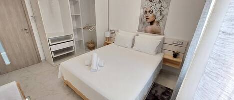 A bedroom with a bed, a wardrobe, a nightstand, and a wall-mounted artwork.
