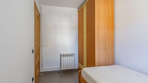 A bedroom with a wooden wardrobe, a radiator, and a bed. - Penthouse with Private Sun Deck, BBQ, and Beach (Cunit)