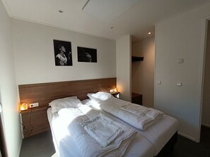A hotel room with a double bed, two bedside tables with lamps, a wooden headboard, and two framed pictures on the wall. - Holiday Home in Otterlo With Terrace (Otterlo)