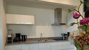 A modern kitchen with a built-in oven, a coffee maker, and a sink. - Holiday Home in Otterlo With Terrace (Otterlo)