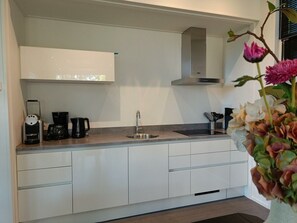 A modern kitchen with a built-in oven, a coffee maker, and a sink. - Holiday Home in Otterlo With Terrace (Otterlo)