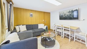 Un salon moderne comprenant un canapé, une table basse et un coin repas avec des chaises et une table.