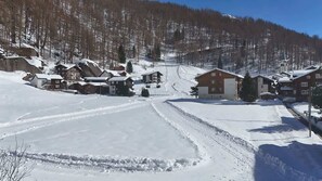 A snow-covered village with houses, a ski slope, and a church.