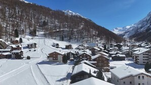 A snow-covered village with buildings, a church, and a ski slope. - Alpine Suite near Saas-Fee | Mountain Views (Saas-Almagell)