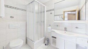 A modern bathroom with a toilet, shower enclosure, sink, and mirror. - Alpine Suite near Saas-Fee | Mountain Views (Saas-Almagell)
