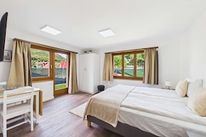 Une chambre à coucher avec un lit, un bureau et une vue sur l’extérieur.