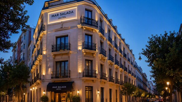 A multi-story hotel with balconies, a prominent entrance, and a clear sky. - Hotel Mar Salada (Madrid)