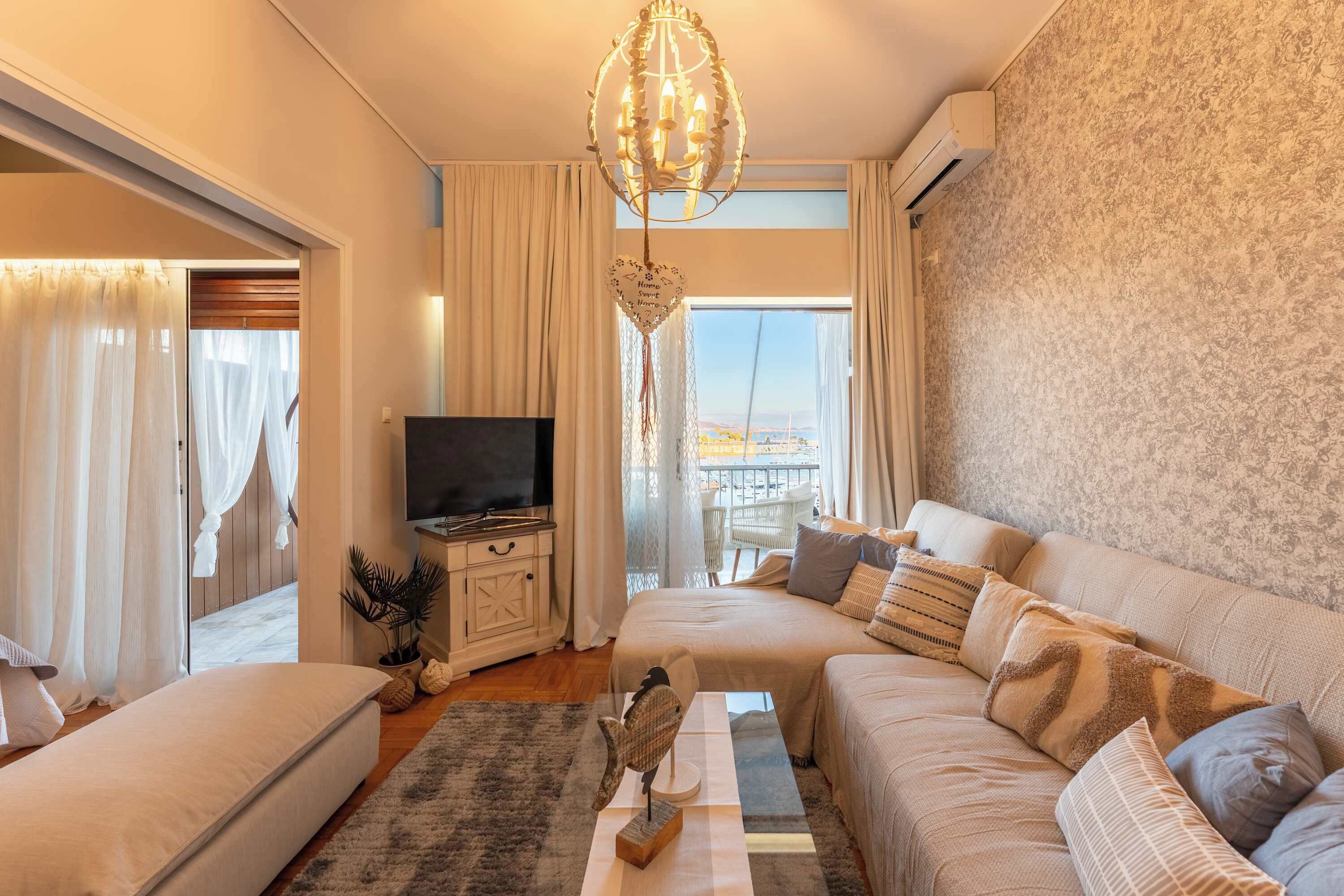 A modern living room with a sofa set, a television, a decorative bird sculpture, and a view of the outdoors.