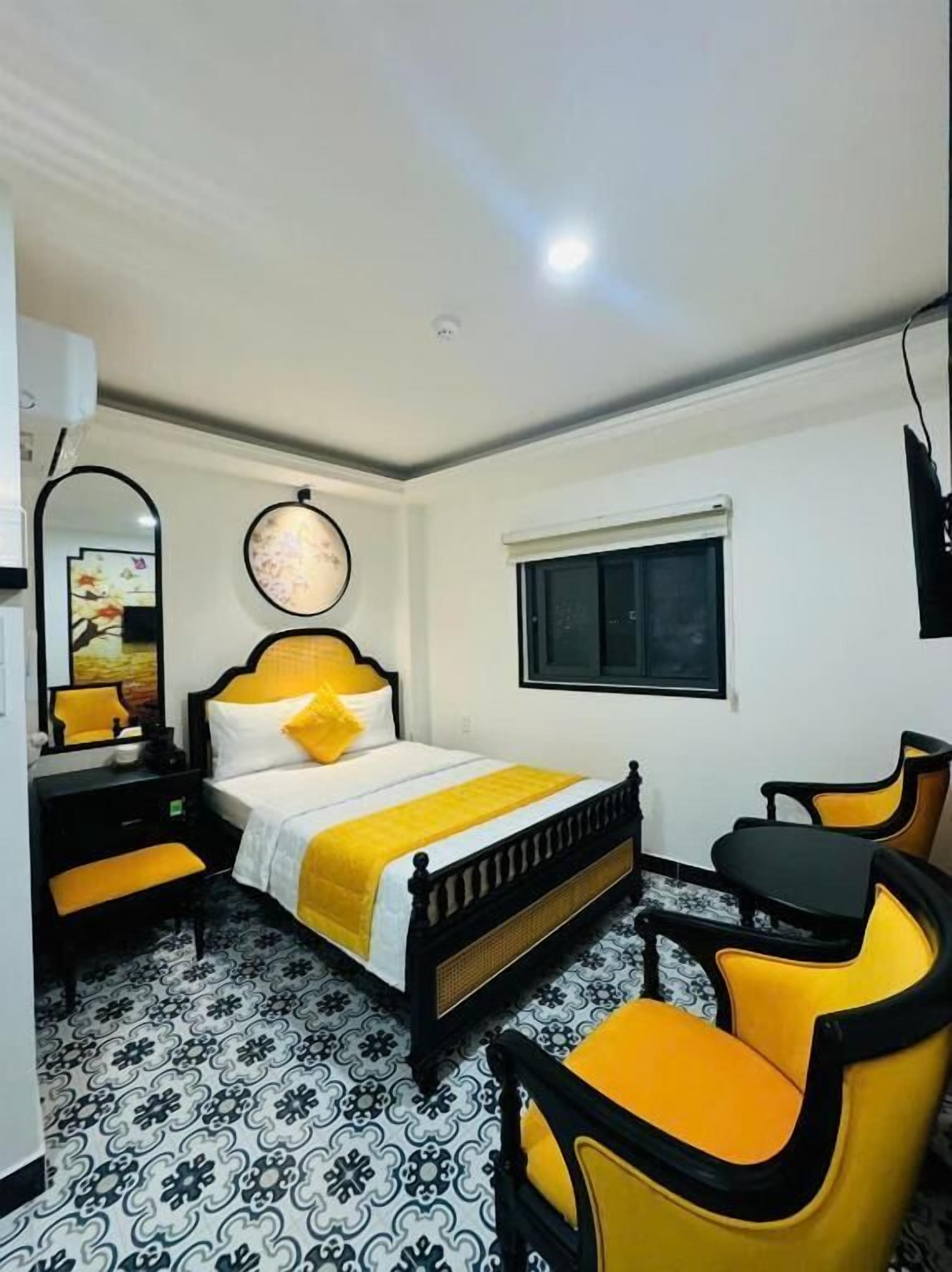 Quarto com cama, mesa de cabeceira, cadeira e janela.