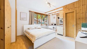 Un dormitorio con una cama, un escritorio y una silla.
