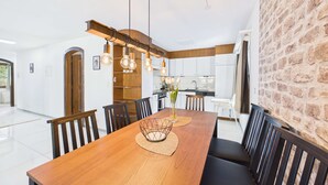 Un comedor moderno con una mesa de madera, sillas negras y una lámpara colgante.