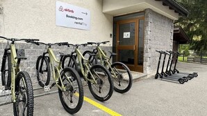 Rakennuksessa on Airbnb-kyltti, ovi ja pysäköintialue, jossa on pyöriä ja potkulautoja.