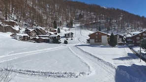 A snow-covered village with houses and a ski slope.