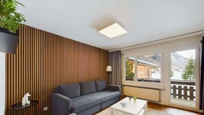 Een moderne woonkamer met een bank, een salontafel en een potplant.