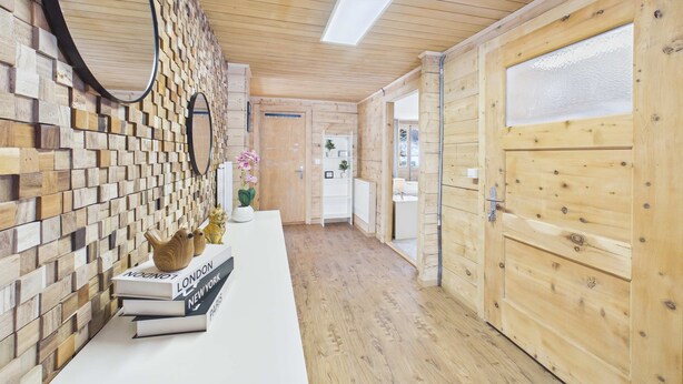 A wooden interior with a reception desk, books, and a mirror.