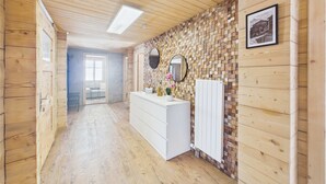 A wooden interior with a white dresser, a mirror, and a radiator.
