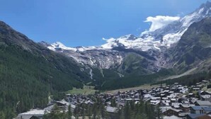 Un paisaje montañoso con un pueblo pequeño en un valle.