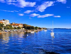 A waterfront with boats, a marina, and buildings along the shore. - Casa Renoir: A bright one-bedroom apartment in the historic center of Suna, near the lake and the beach  (Suna)